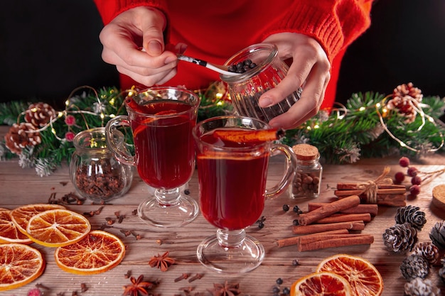 Christmas mood holiday atmosphere The girl prepares mulled wine on a wooden table