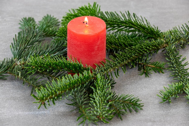 Photo christmas motif texture wallpaper background with branches of a nordmann fir and red candle