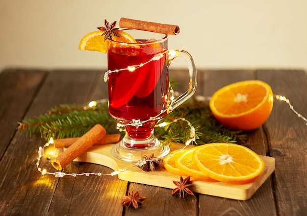 Christmas mulled wine red wine with spices and fruits on a wooden rustic table. Traditional hot drink for Christmas.Horizontal frame