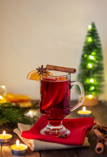 Christmas mulled wine red wine with spices and fruits on a wooden rustic table. Traditional hot drink for. ChristmasVertical frame.