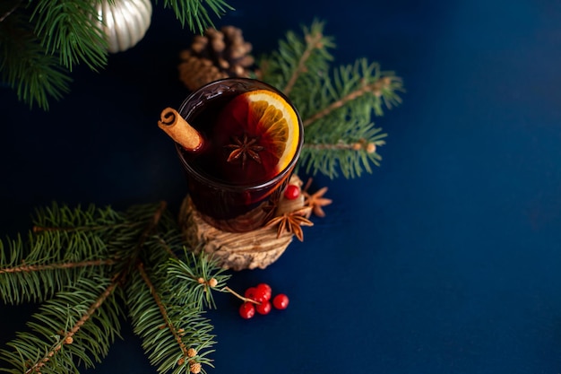 Christmas mulled wine with cinnamon stick, orange, anise and cloves on a blue background. Winter holidays.