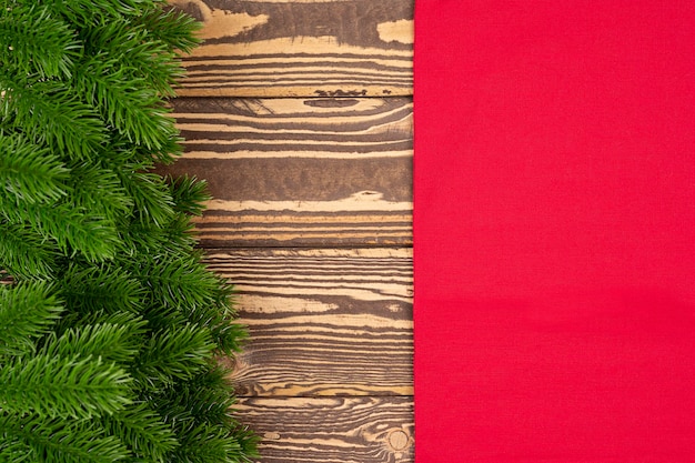 Christmas and New Year background Fir tree branches on wooden background with red napkin