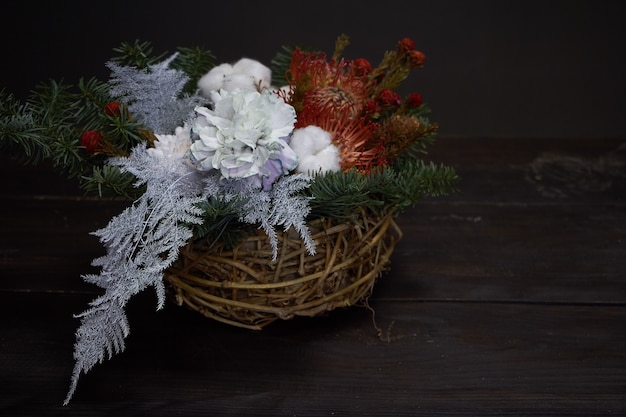 Christmas and New Year composition. Wicker basket with fir branches decorated by natural materials on dark