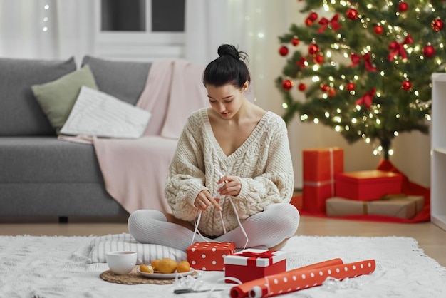 Christmas and new year gift wrapping by woman at home during winter holidays