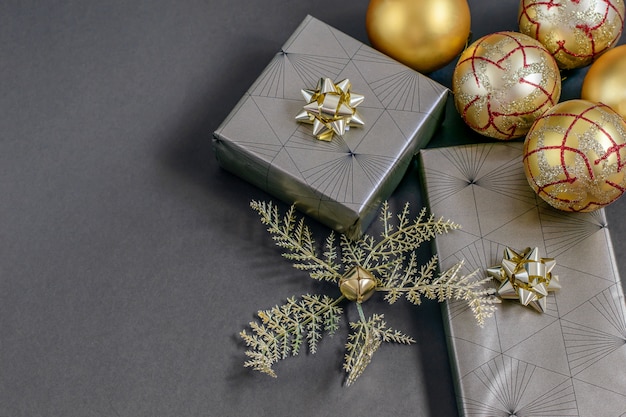 Christmas and New Year handmade wrapping gift boxes, golden ribbons, balls and baubles on the black.