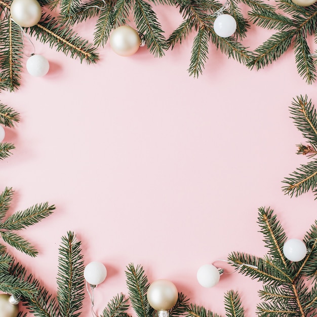 Christmas New Year holiday composition. Mock up frame with blank copy space, fir needle branches, Christmas baubles on pink