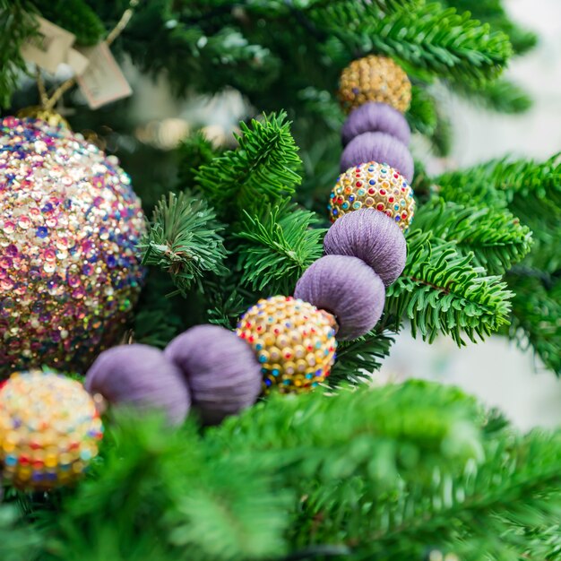 Christmas and New Year holidays background. Christmas tree decorated with baubles and garlands. Glittering and sparkling. Celebration concept