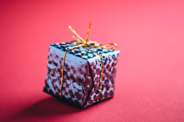 Christmas New Year Holidays gift box on red pink background close up shadows