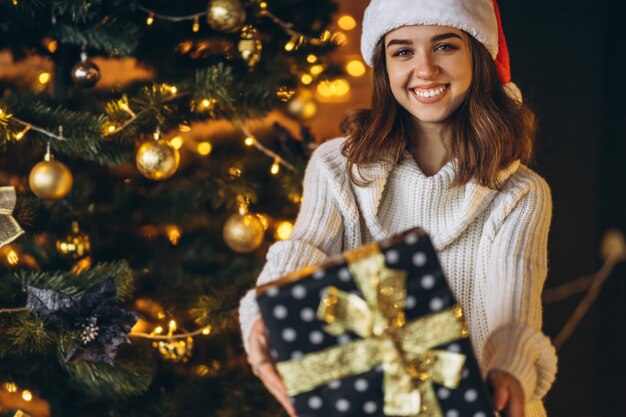 Christmas, New Year. Pretty woman in warm sweater, socks and christmas hat, decorating new year tree