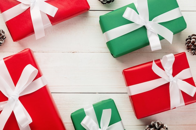 Christmas and new year with gift boxes and snow pine cone decoration on white wooden table