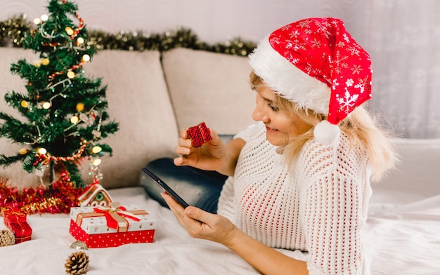 Christmas online shopping. Female buyer makes order on mobile phone