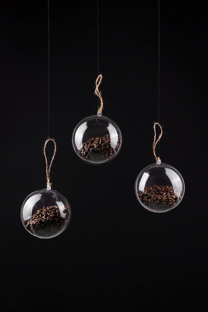 Christmas ornament balls with coffee beans on black background with copy space