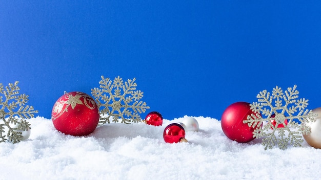 Christmas ornaments on snow over blue background. Winter Christmas background