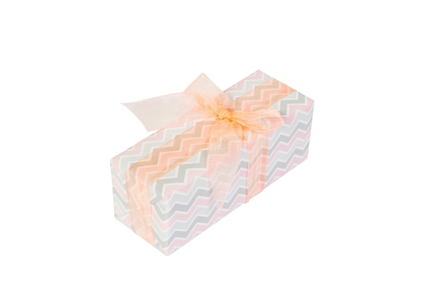 Christmas or other holiday handmade present in colored paper with orange ribbon