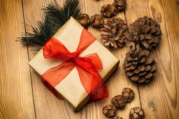 Christmas package with red ribbon on a rustic wooden table