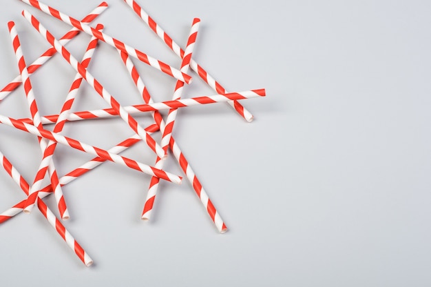 Christmas paper striped cocktail straws on gray background