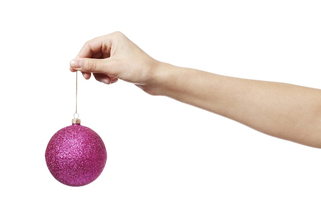 Christmas pink toy ball for the Christmas tree Ñn hand isolated on a white background.