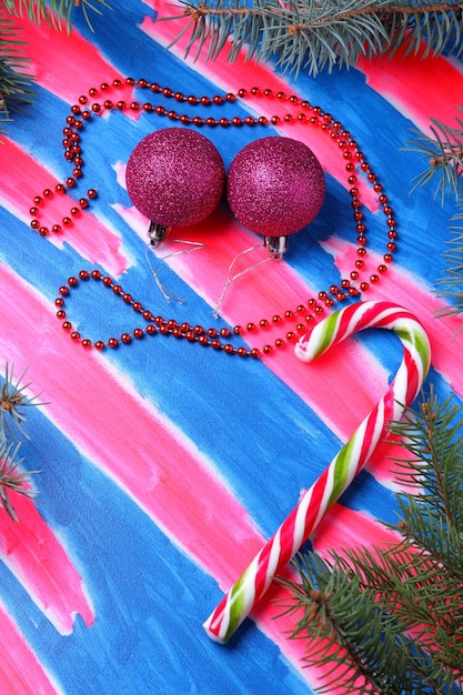 Christmas pink toys candy cane Christmas tree branches on a bluepink background Christmas concept Closeup