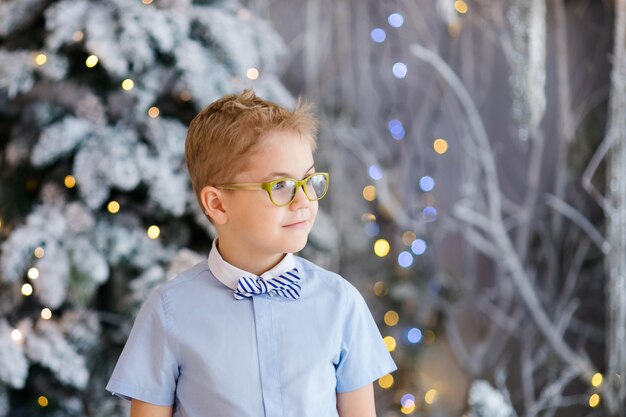 Christmas portrait of happy child boy with big glasses indoor studio