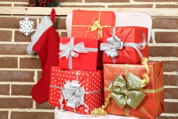 Christmas presents on chair on brown brick wall background