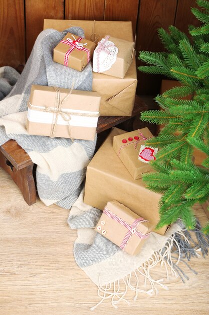 Christmas presents  near Christmas tree on wooden surface