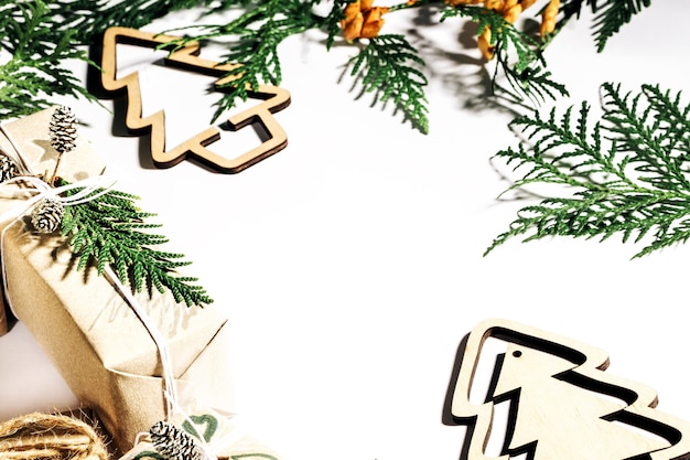 Christmas presents with gift box decorated with pine cones and twigs on white background, preparation for holidays. Selective focus.