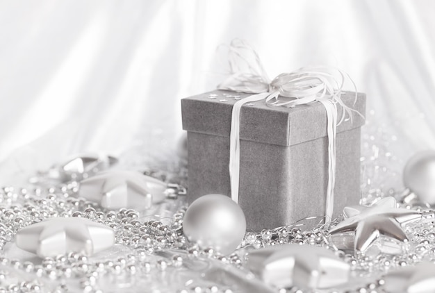 Christmas presents with silver ribbon on white wooden background