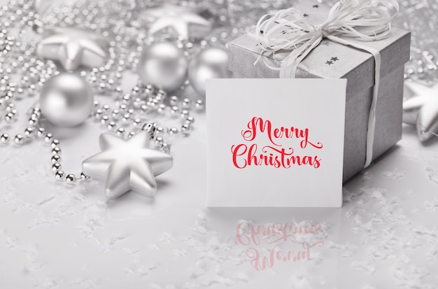 Christmas presents with silver ribbon on white wooden background