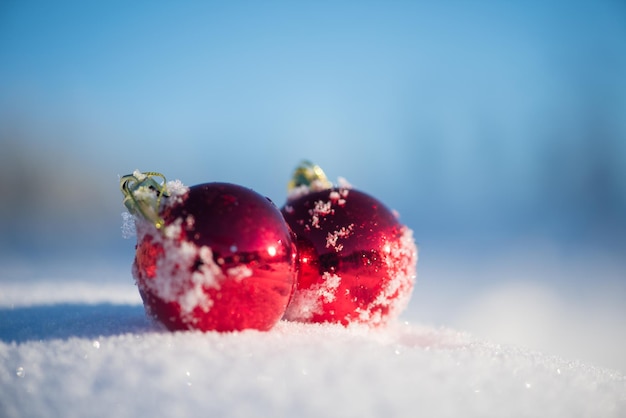 christmas red balls with long shadows  in fresh snow on beautiful sunny winter day