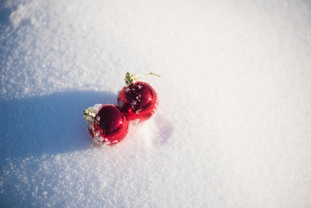 christmas red balls with long shadows  in fresh snow on beautiful sunny winter day