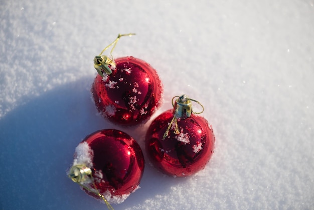 christmas red balls with long shadows  in fresh snow on beautiful sunny winter day