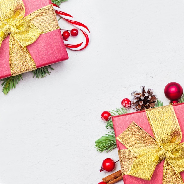 Christmas red gift boxes with golden ribbon and bow on white background, flat lay top view with copy space