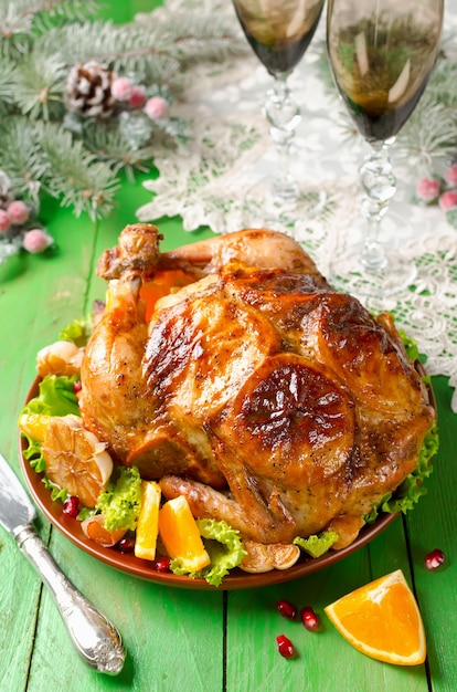 Christmas roast chicken stuffed with oranges and decorated with orange slices and fried garlic