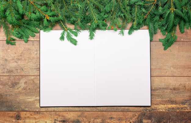 Christmas rustic mockup sheet of white paper lies on an old table decorated with Christmas fir branches on old wooden table christmas mock up