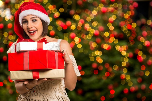 Christmas Santa hat isolated woman portrait hold christmas gift. Smiling happy girl over Christmas background