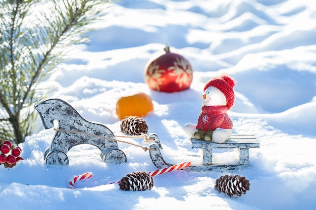 Christmas Scene, snowman sitting on a sled