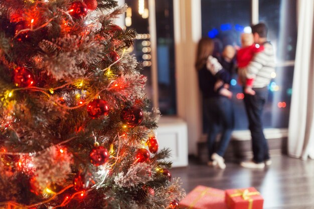 Christmas scene with happy family of four tree gifts and window