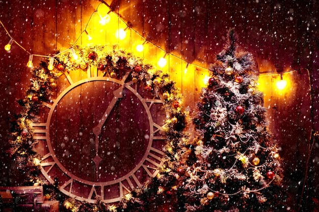 Christmas scene with tree gifts and fire in background. Old big street clock on wall of the building. New year, holiday concept