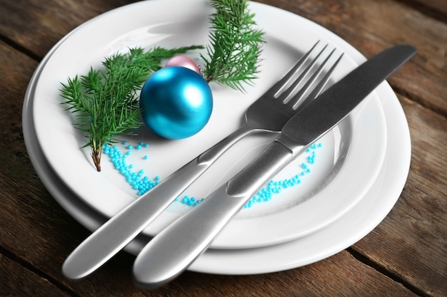 Christmas serving cutlery with plate on a wooden background, close up