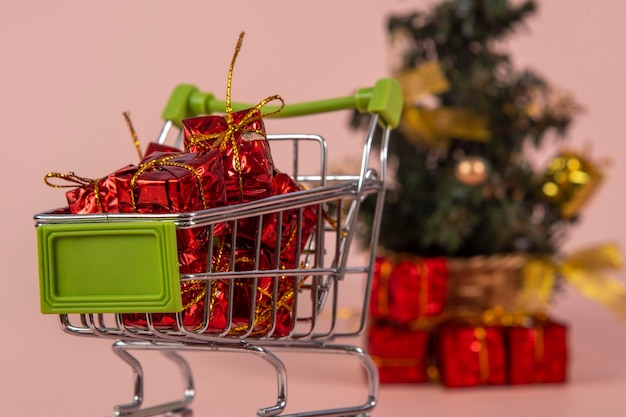 Christmas shopping cart with gifts and Christmas tree in background