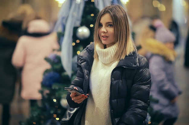 Christmas shopping girl city, young model evening gift shopping, seasonal sale, winter evening outside in the city