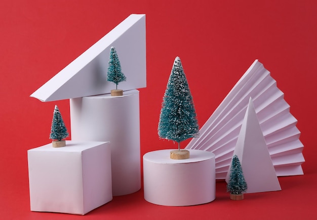 Christmas showcase Geometric shapes mini Christmas trees on red background Concept art minimalism