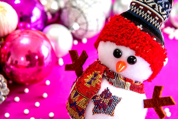 Christmas snowman in christmas decoration with pink background