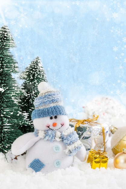 Christmas snowman with gifts on snowy background