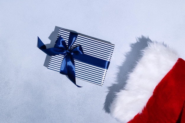 Christmas sock and Christmas gift with blue ribbon on grey background Space for text Mockup