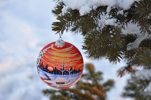 christmas sphere on the fir branch in the snowy forest, close-up