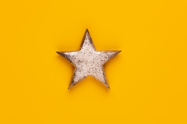 Christmas star decor on yellow colored background.