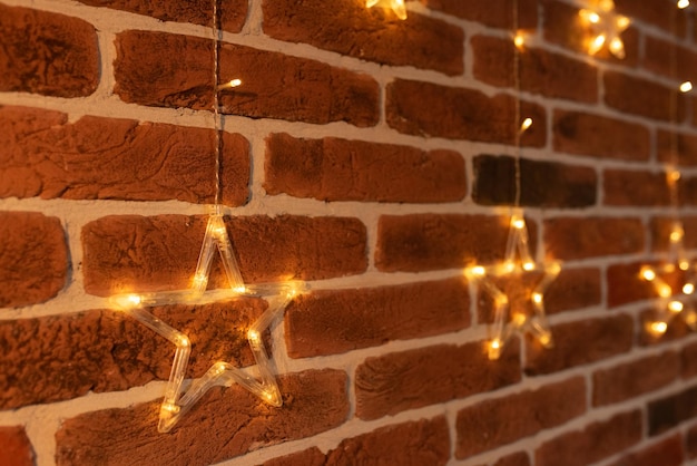 Christmas star hanging on a red brick wall Christmas garland