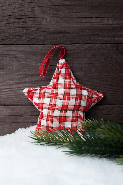 Christmas star and tree on snow over wooden background