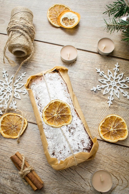 Christmas stollen on wooden background Traditional new year german sweet dessert Cake with nuts oranges marzipanpowdered sugar and dried fruit on table baking food for xmas eve